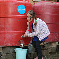 Fotografia de nina accediendo a agua segura en medio del conflicto en siria