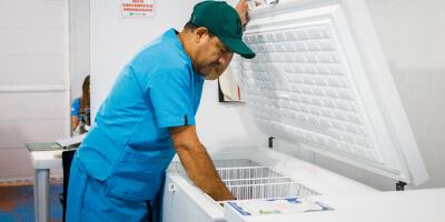 funcionario de UNICEF sacando vacunas de una nevera