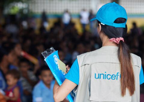 funcionaria de UNICEF de espalda ayudando en terreno