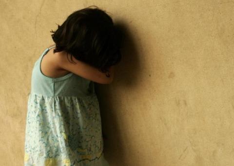 niña llorando contra pared