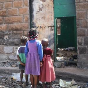 niños mirando a una pared en ruinas