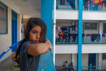 nina en un albergue en gaza para refugiados mirando la camara