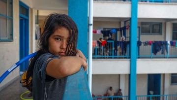 nina en un albergue en gaza para refugiados mirando la camara