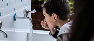 Niño tomando agua potable UNICEF