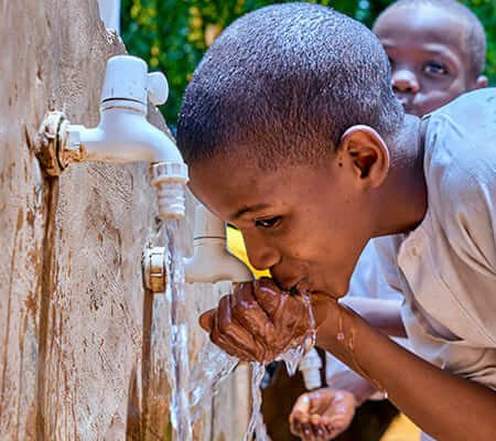 Niños bebiendo agua potable gracias a UNICEF — dona aquí para garantizar acceso al agua y saneamiento básico en comunidades vulnerables