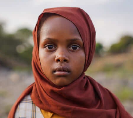 Niña refugiada afectada por conflictos globales — dona aquí y ayuda a UNICEF a proteger la infancia en zonas de guerra